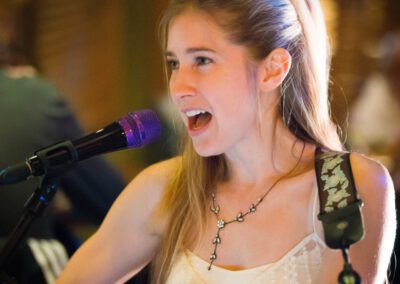 A girl singing into a microphone at an event.
