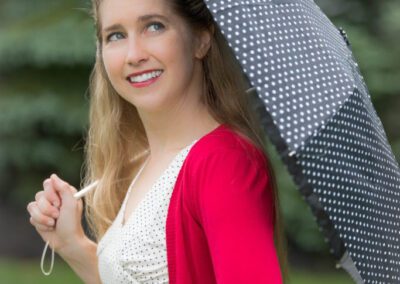 A woman holding an umbrella while standing outside.