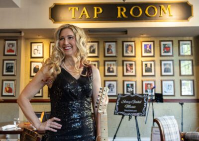 A woman standing in front of a sign that says " tap room ".